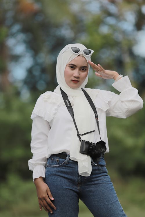 Woman in White Hijab and Blue Denim Jeans Touching Her Head