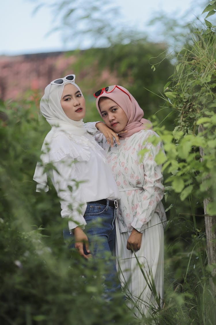 Portrait Of Young Women Wearing Scarves In Green Bushes