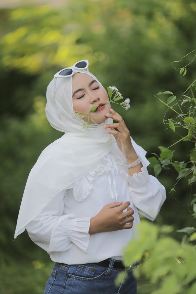 Woman In White Shirt Smelling Flowers