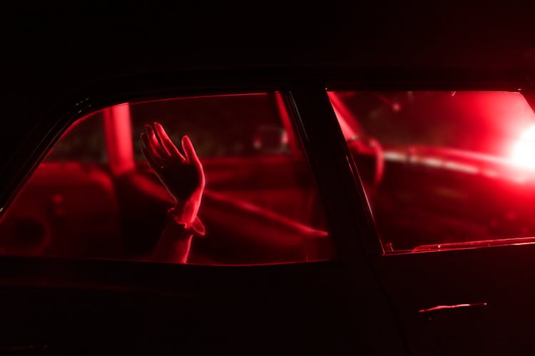 Hand Waving From Car In Darkness