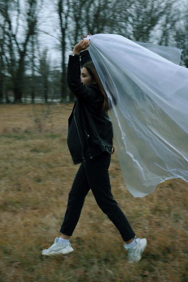 Woman On A Field Carrying A Plastic Foil 