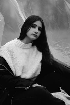 Elegant black and white portrait of a young woman in a cozy sweater.