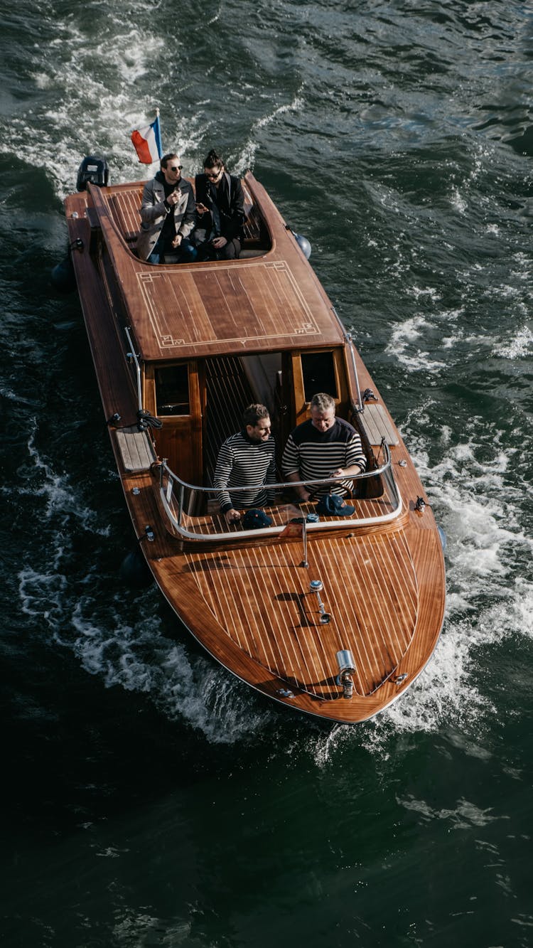 Small Group Of People Travelling On Motorboat With Wooden Deck 