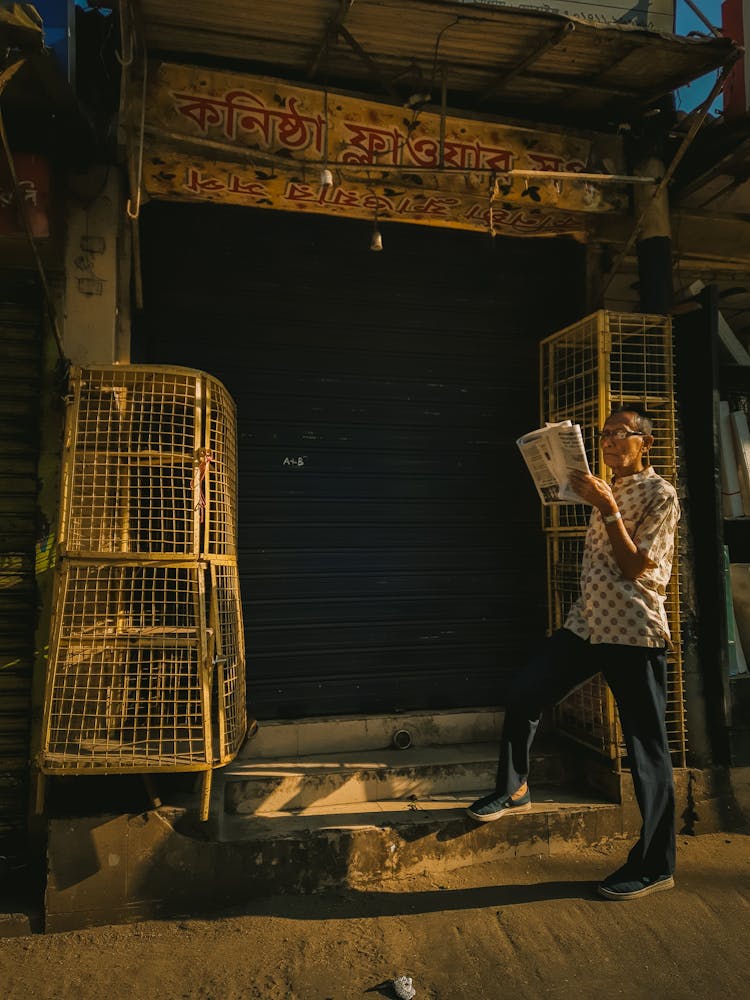 Man Standing And Reading Newspaper