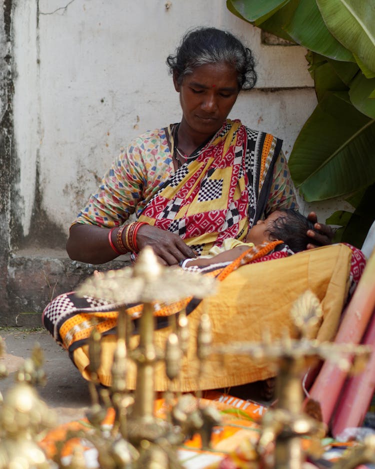 A Baby Sleeping On The Woman's Lap 