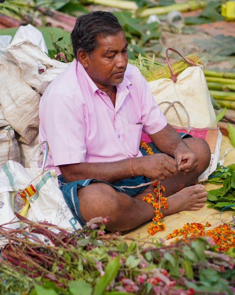 Man In Market Making Flower Necklace