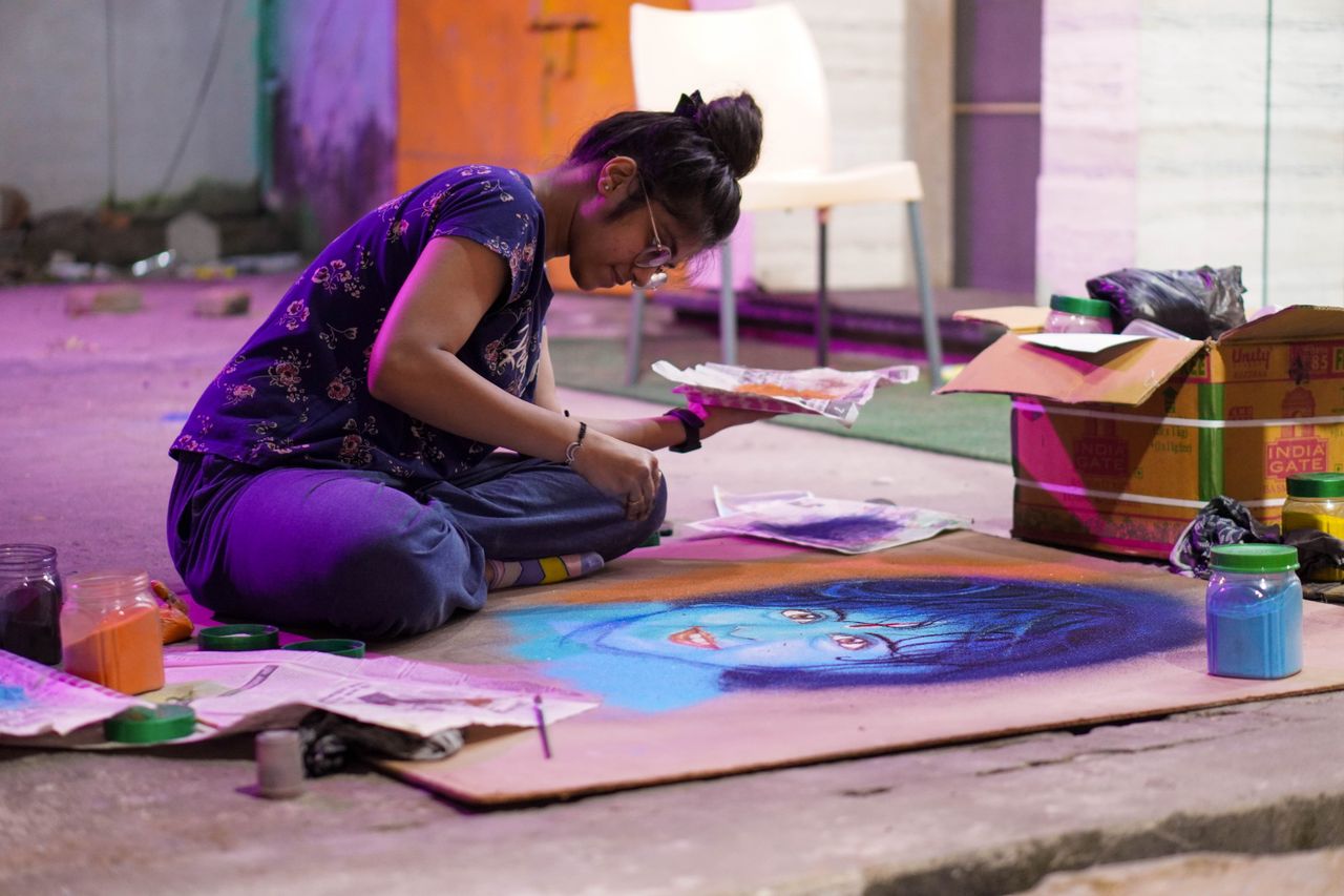 a young artist focused on creating a vibrant chalk portrait indoors