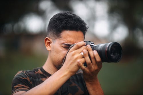 Free Man in Black and Brown Camouflage Shirt Taking Photos Using a Black Dslr Camera Stock Photo