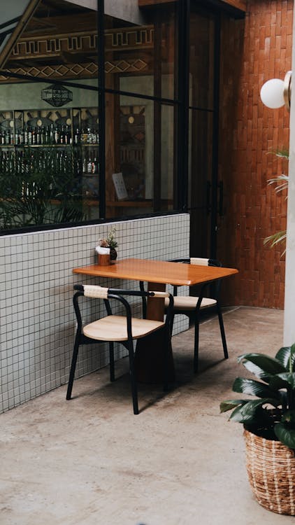 Brown Wooden Table and Chairs Outside the Restaurant 