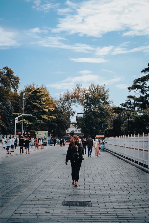 Free People walking along a tree-lined pedestrian path in Istanbul, showcasing urban lifestyle. Stock Photo