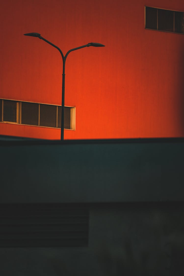 Street Lamp Illuminating Red Facade Of Warehouse Building In Background