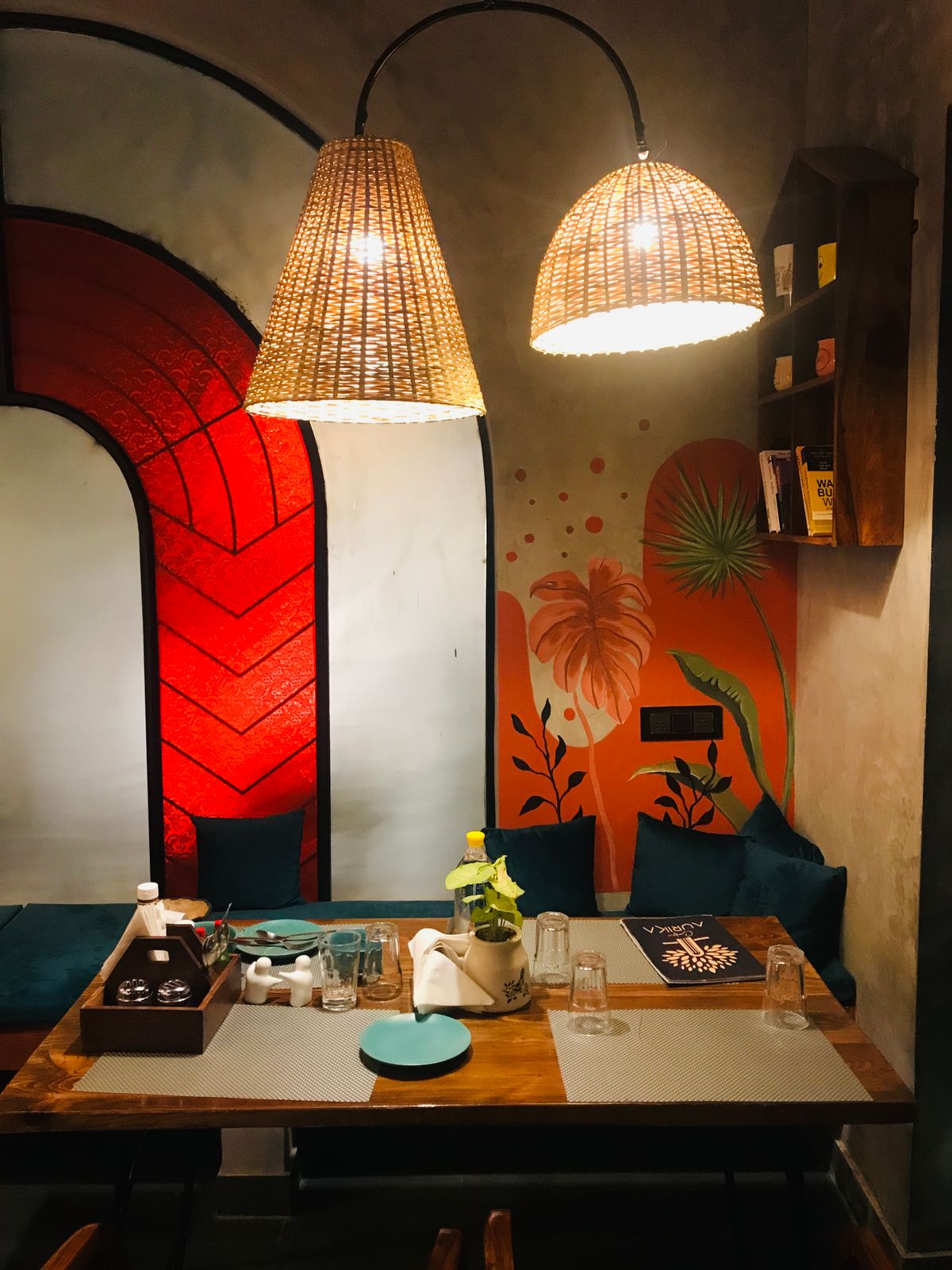 Warm restaurant interior with lighting and a colourful mural