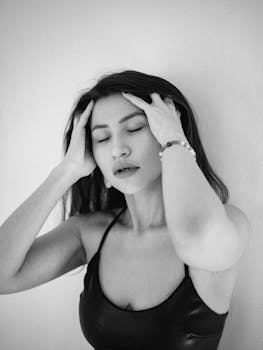 Artistic black and white portrait of a woman with eyes closed, expressing emotion.