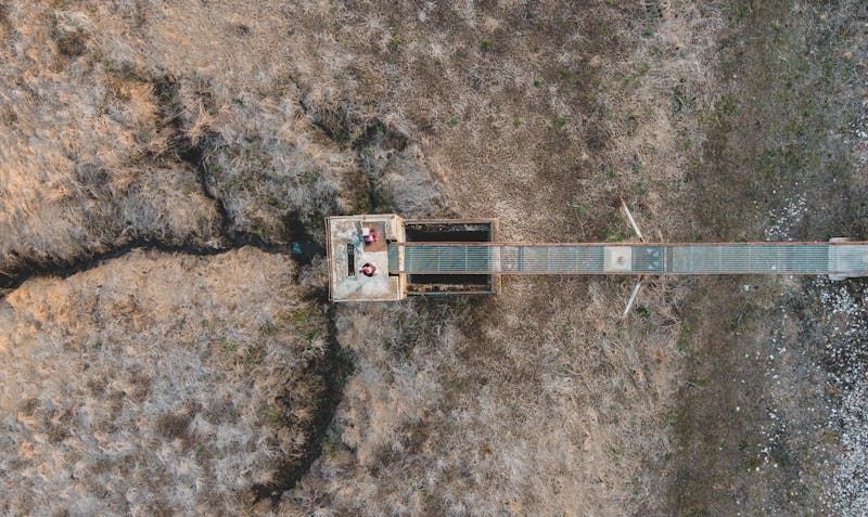 Vue aérienne d'un pont solitaire au-dessus d'un paysage désertique en Roumanie