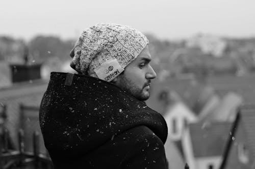 Grayscale Photo of a Man While Snowing