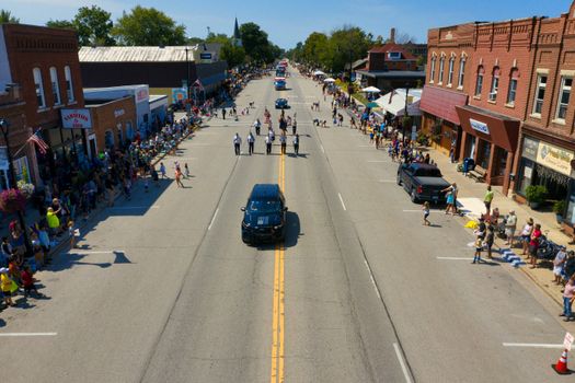 Aerial perspective capturing a vibrant parade on a sunny day in Plainview, MN.