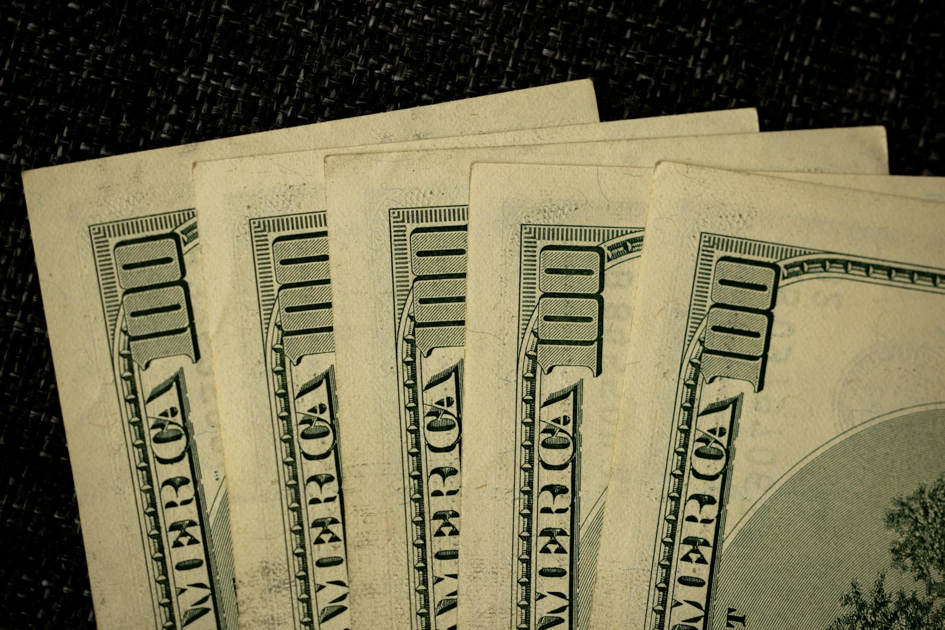 Detailed image of multiple one hundred dollar bills arranged in a stack.