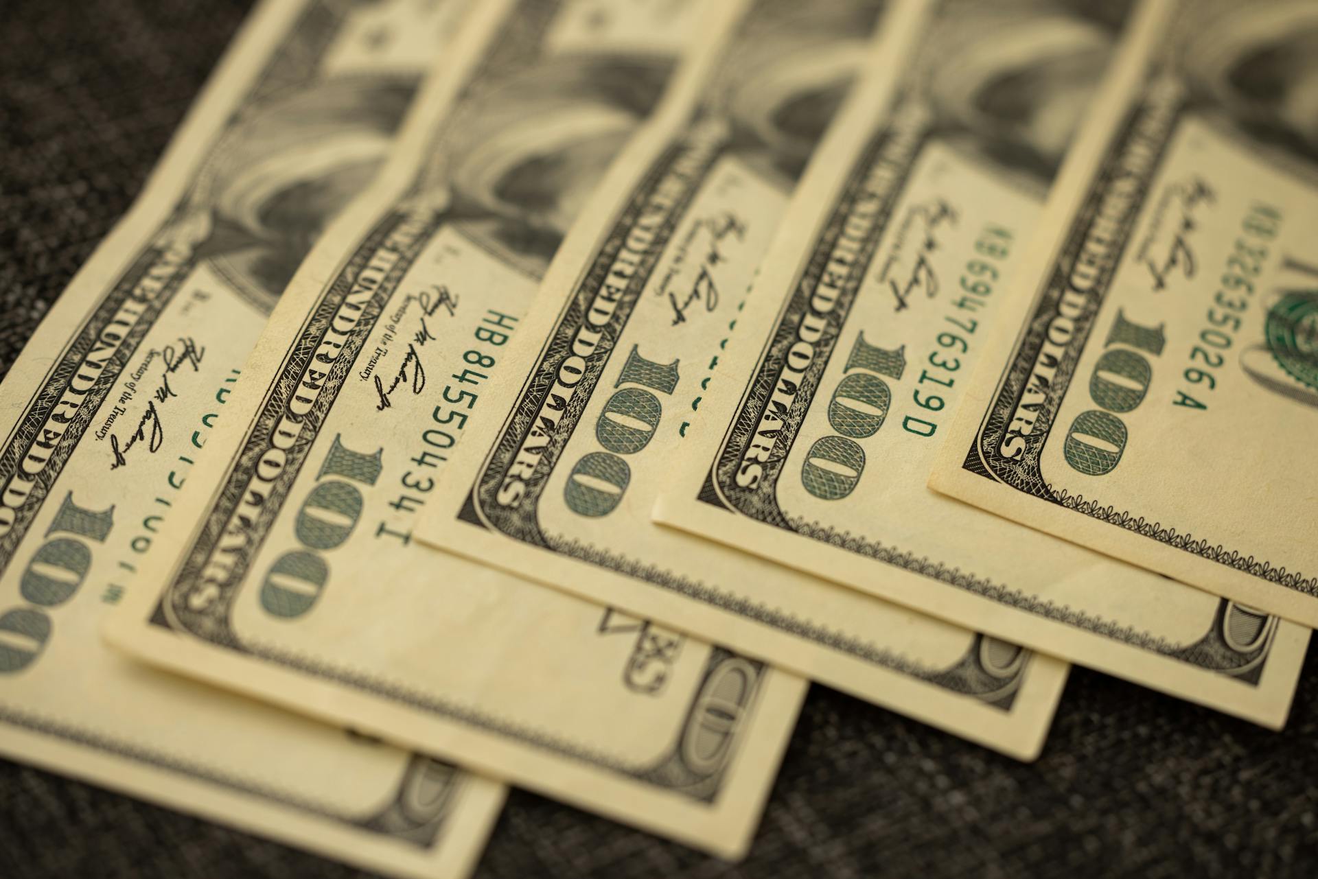 A detailed view of stacked US hundred dollar bills in a close-up shot.