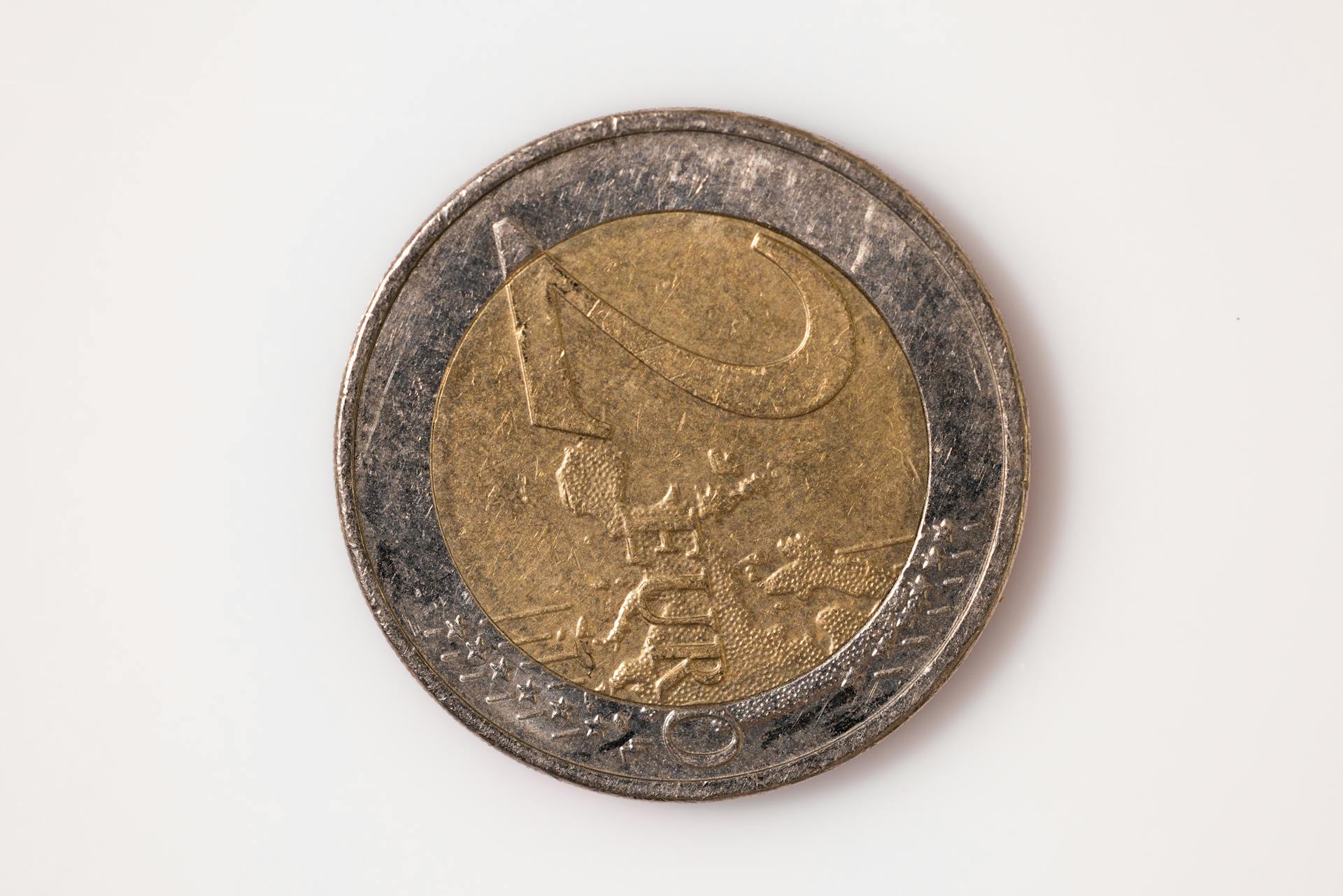 Detailed macro shot of a one euro coin highlighting its intricate design on a white background.