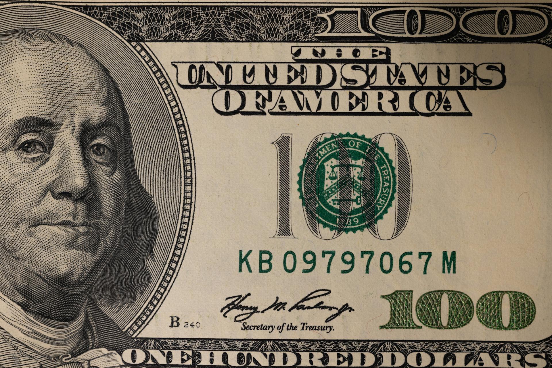 Detailed close-up image of a US one hundred dollar bill showing Benjamin Franklin.