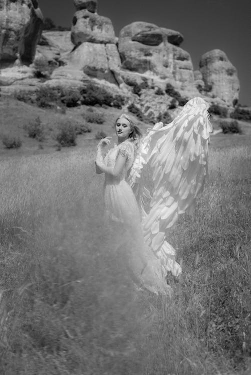 Grayscale Photo of a Woman on Grass Field Wearing Angel Costume · Free ...