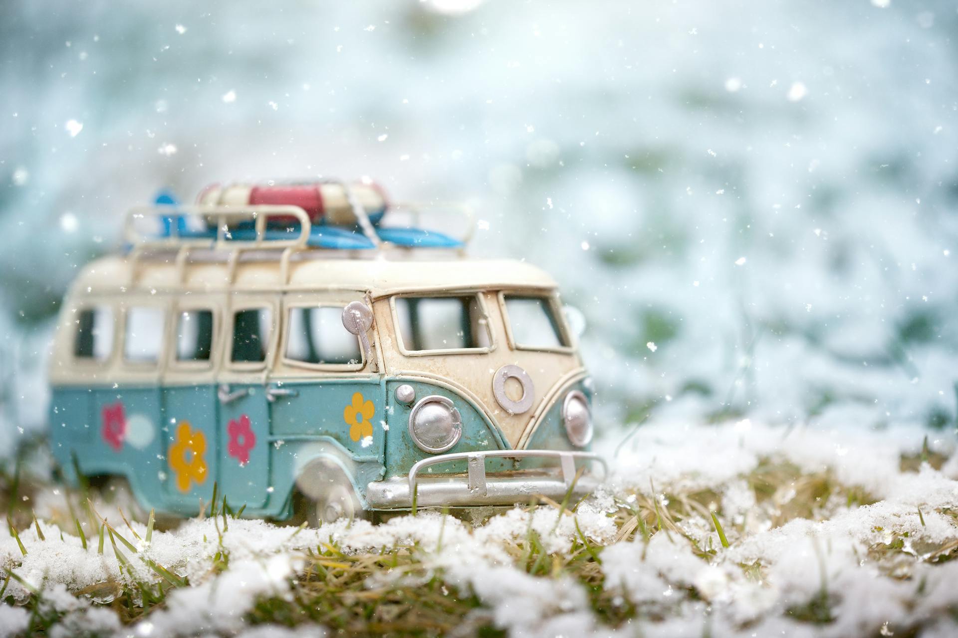 A charming scale model of a Volkswagen T1 amidst a wintry snowfall, evoking nostalgia and adventure.