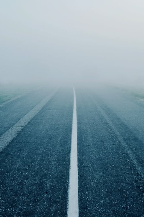 Symmetrical Photo of an Asphalt Road in Fog 