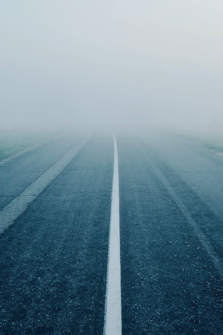 Symmetrical Photo Of An Asphalt Road In Fog 