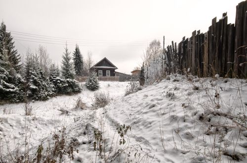Free Charming snow-covered countryside with a wooden cottage and rustic fence. Stock Photo
