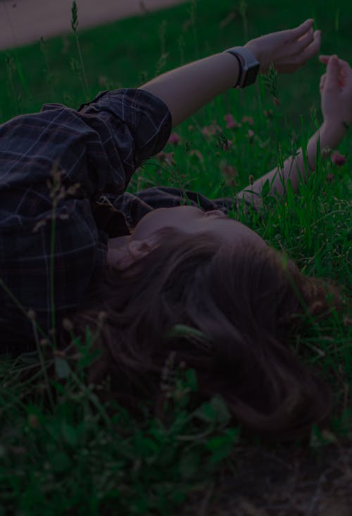 Free Person in Plaid Shirt Lying on Green Grass Stock Photo