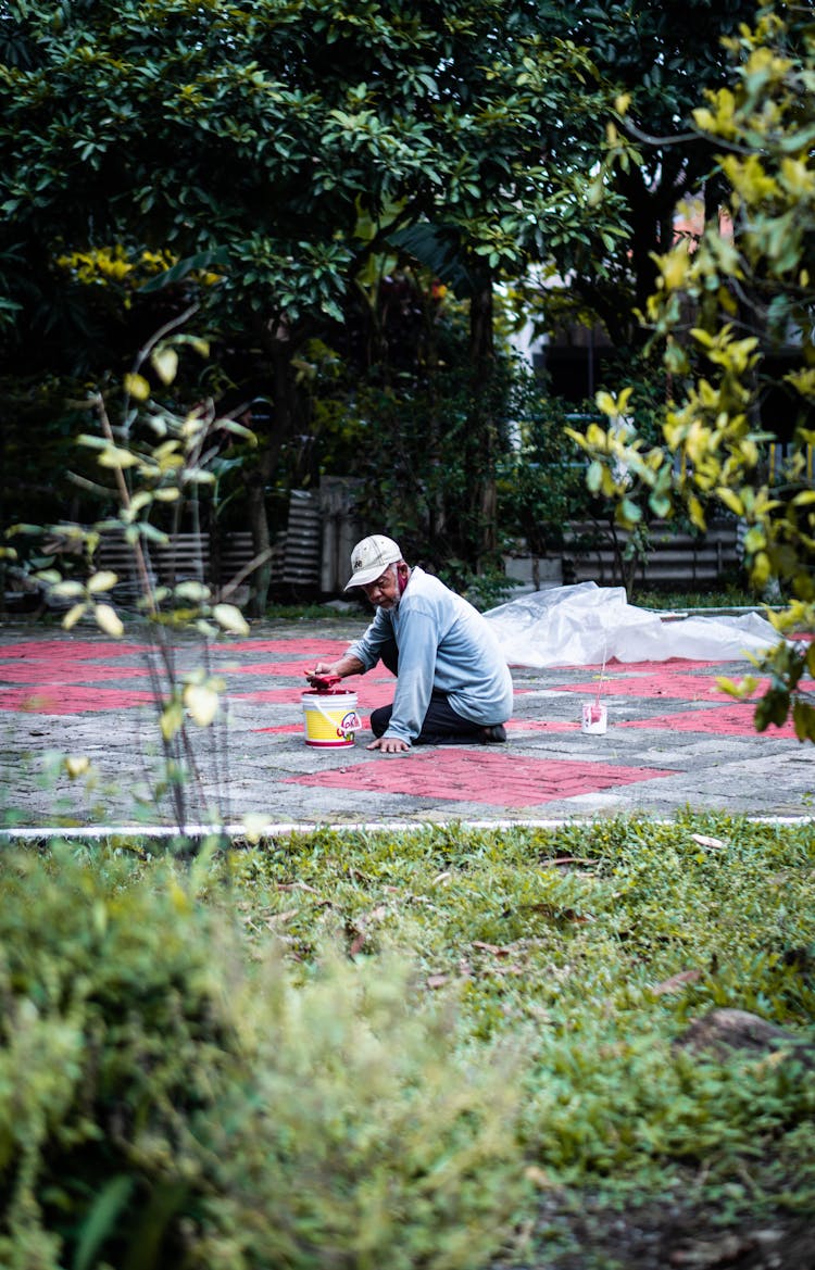 A Man Painting The Pavement