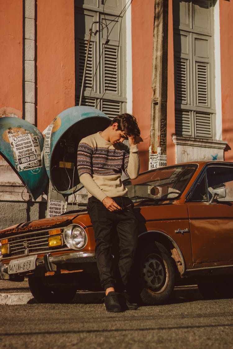 Young Man In Cardigan Standing By Old Fashioned Lumber Car Standing In Town Street