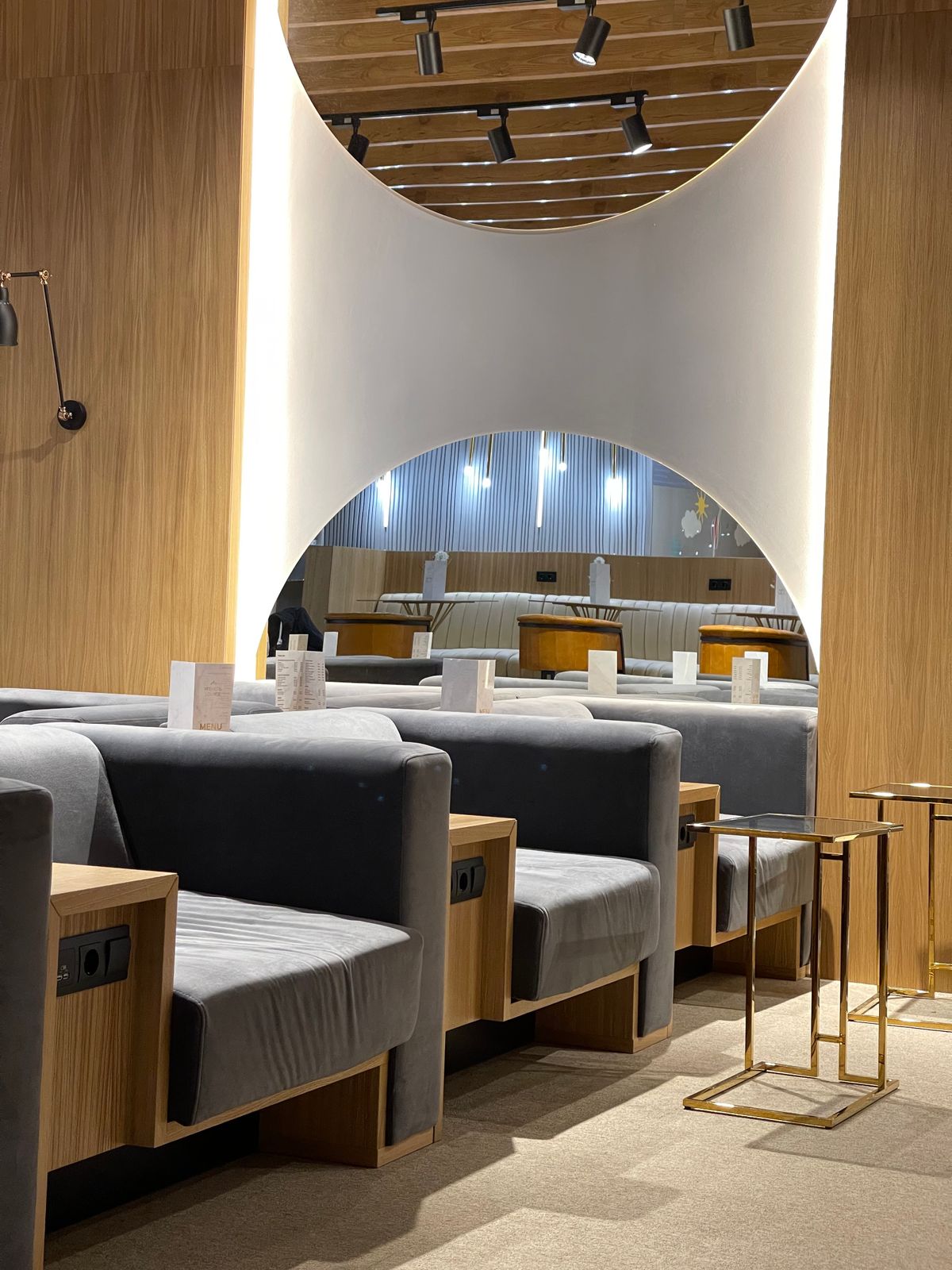 Modern airport lounge seating with private booths and soft lighting