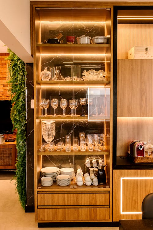 Free Illuminated Kitchen Glass Cabinet with Kitchenware Stock Photo