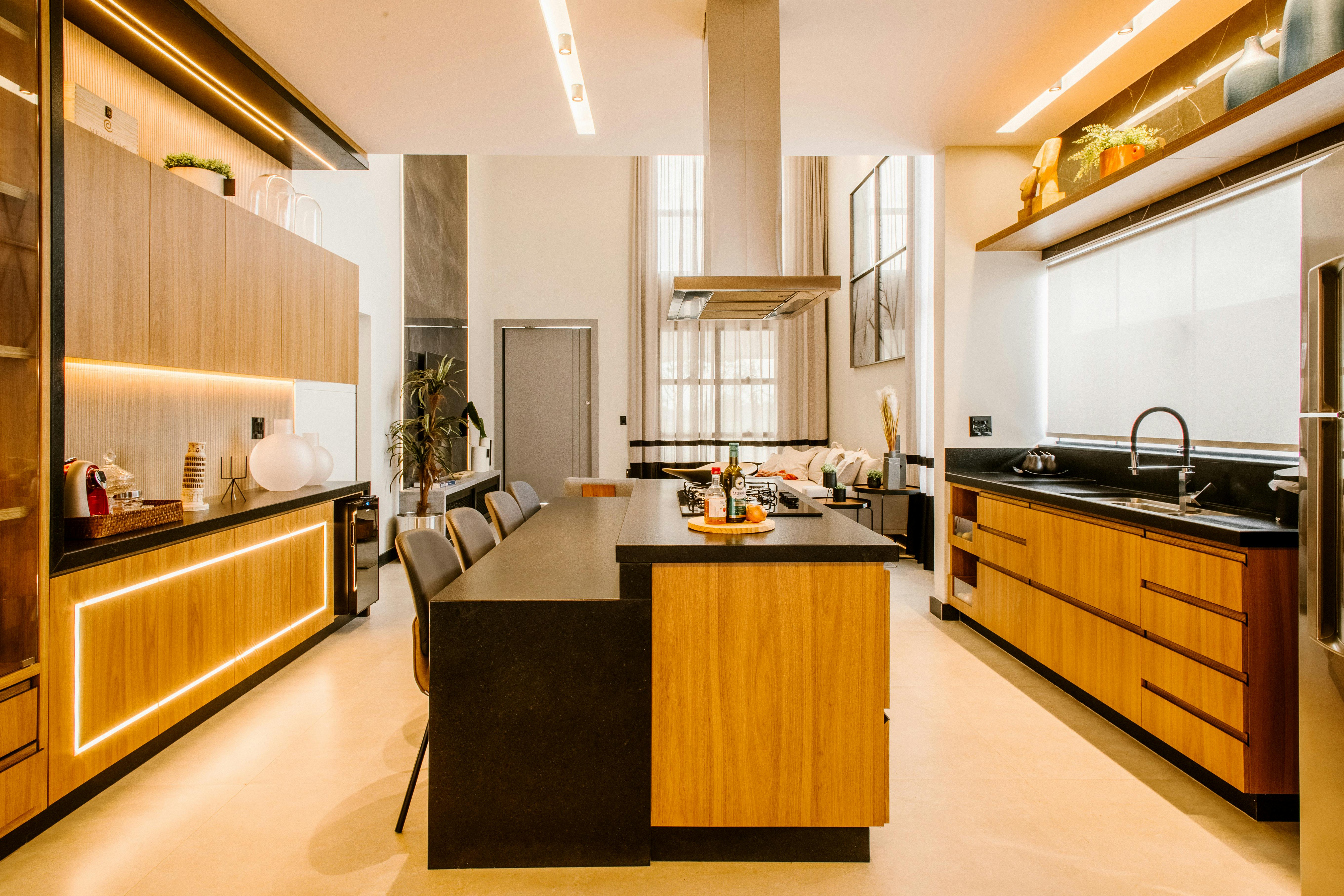 Elegant contemporary kitchen with wood cabinets, black countertops, and warm lighting for a luxurious feel.