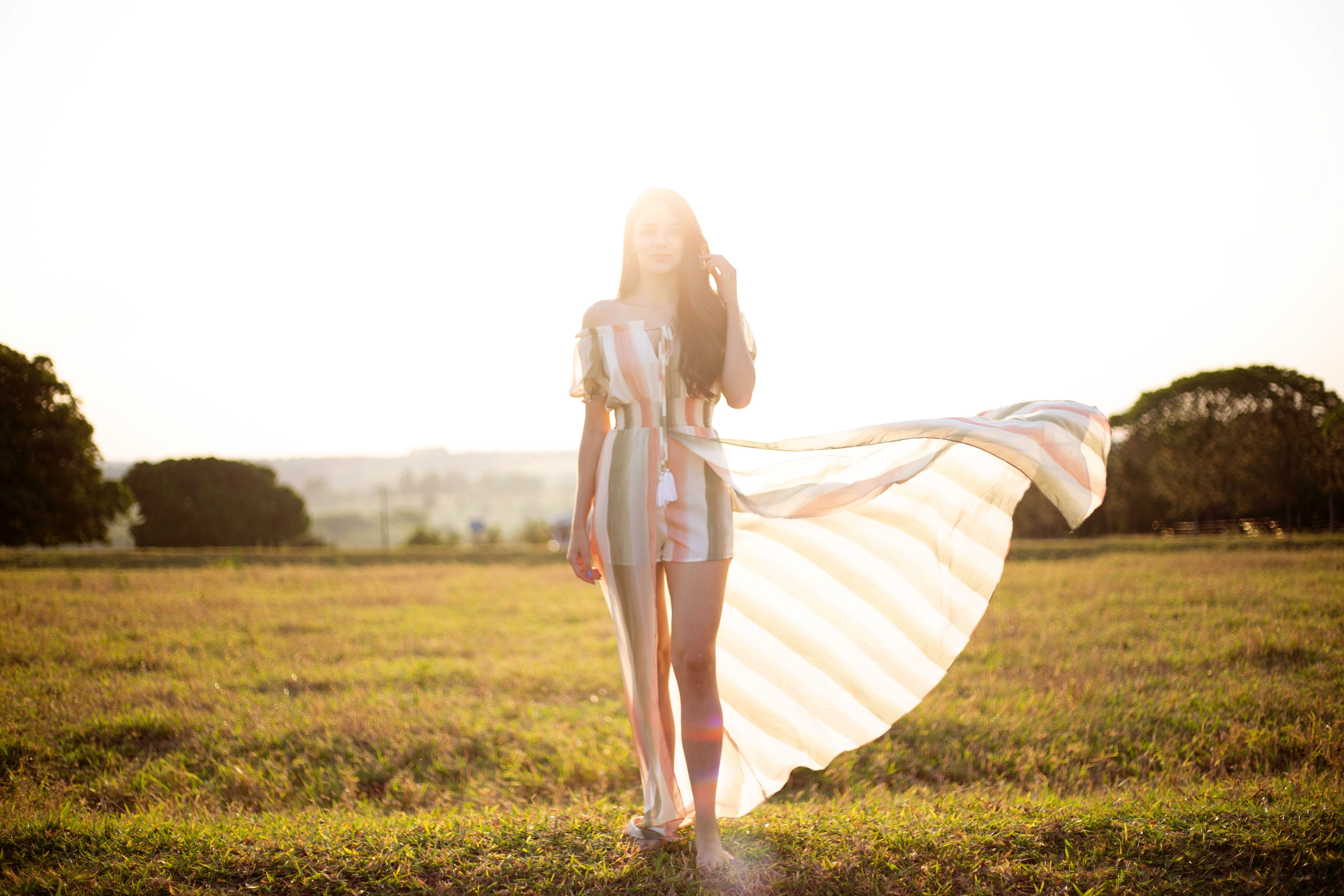 Woman in Dress Standing on Grass Field · Free Stock Photo