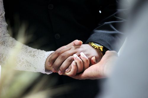 Free Close-up of a bride and groom holding hands, showcasing love and unity on their wedding day. Stock Photo