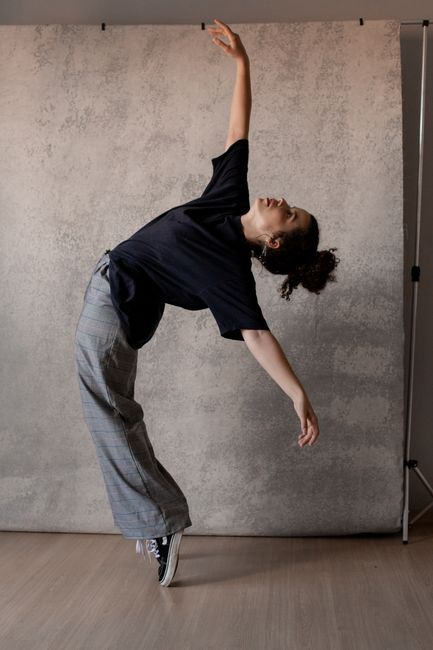 Elegant dancer performing a unique pose in a studio setting.