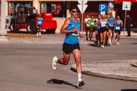 Man in Red Tank Top and Black Shorts Running on Road