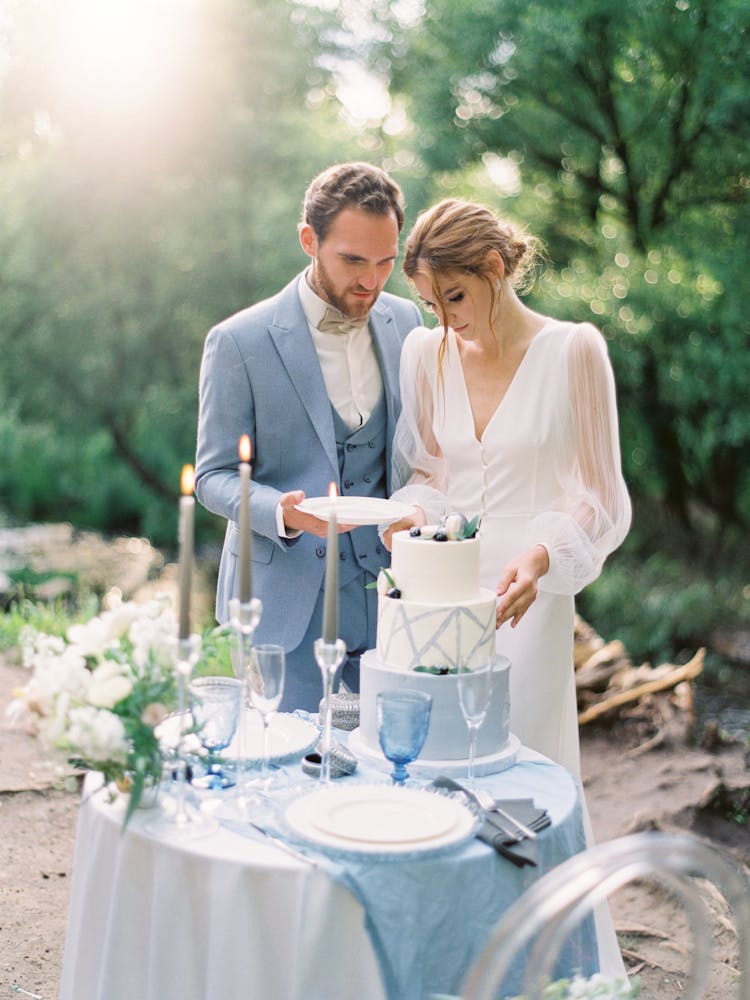 Newlyweds Cutting A Portion Of A Wedding Cake