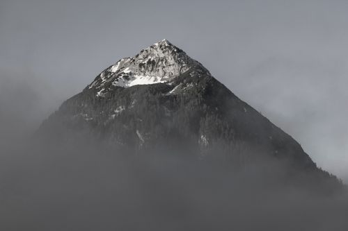 Free Capture of a serene mountain peak shrouded in fog, highlighting natural beauty and tranquility. Stock Photo