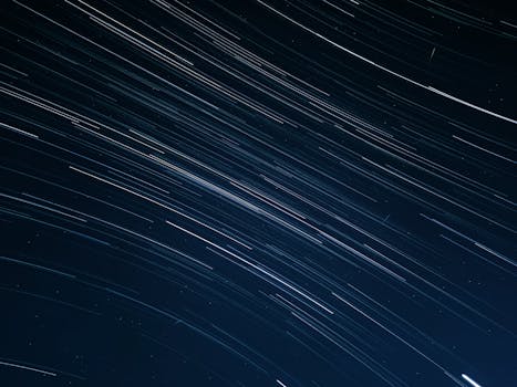 Long exposure photo of star trails in a dark night sky, showcasing celestial motion.