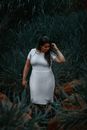 A Woman in White Dress Standing on Grass