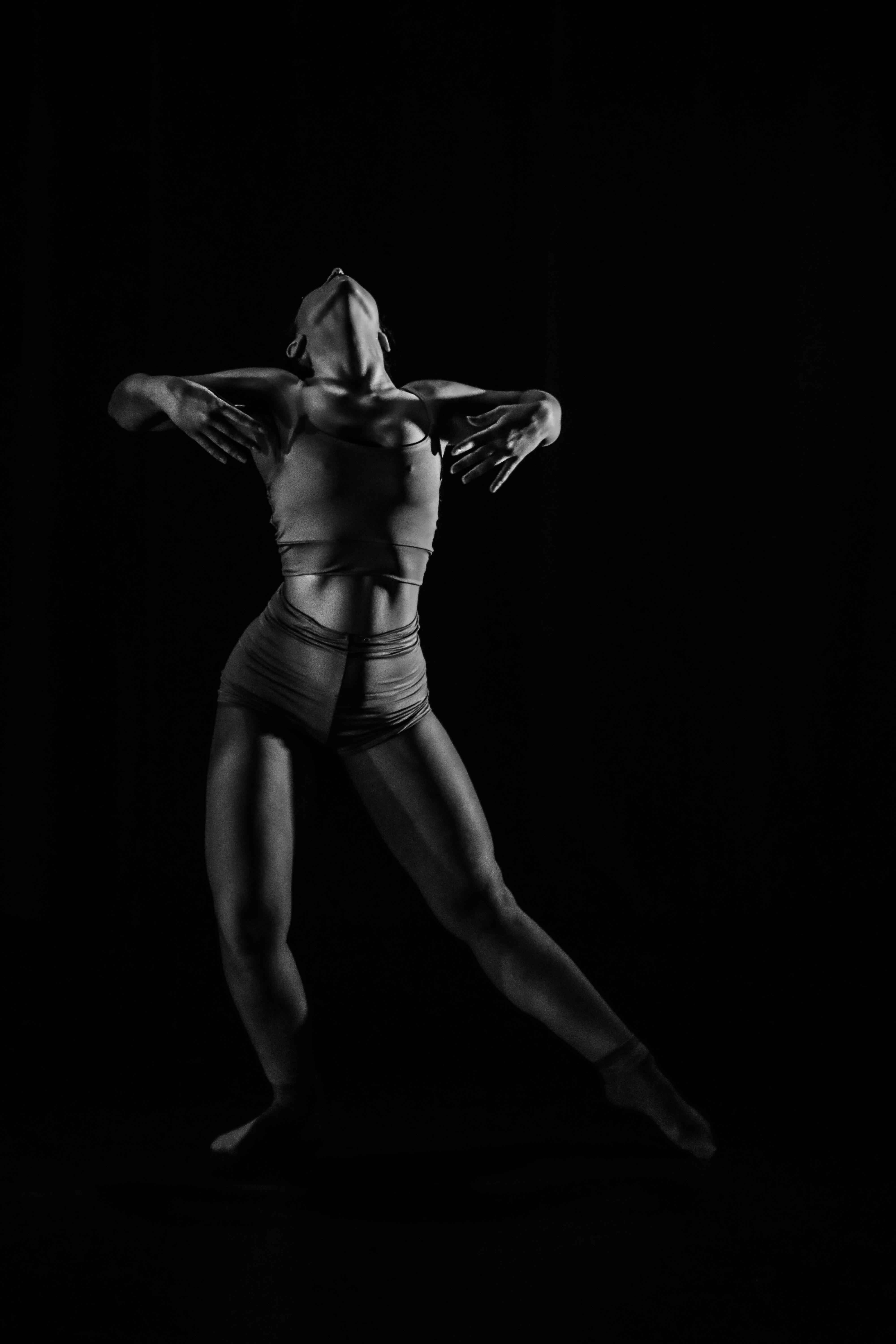Artistic black and white image capturing a dancer in motion, showcasing elegance and strength.