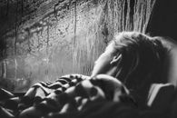 Grayscale Photo of Woman Leaning on Wall