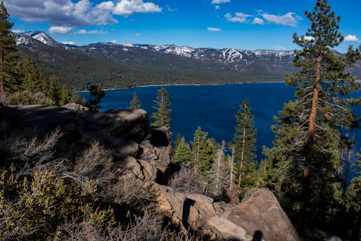 从岩石悬崖上远眺，太浩湖与周围的森林和山脉尽显壮丽景色