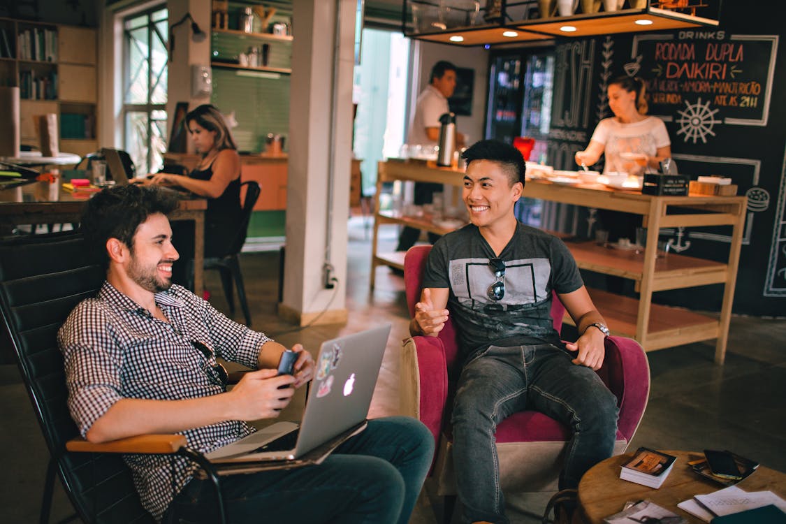 Photograph of Men Having Conversation Seating on Chair