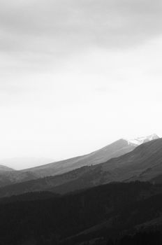 Serene black-and-white view of the majestic Arkhyz mountains under a cloudy sky.