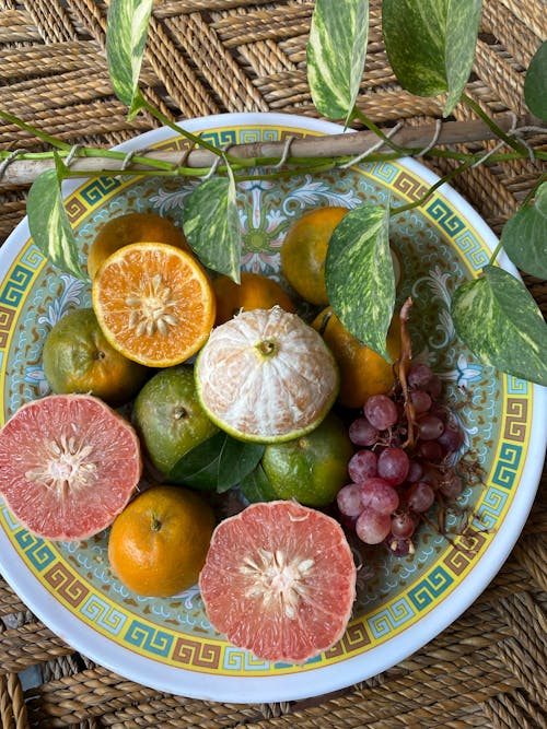Free Citrus Fruits and a Cluster of Grapes on a Plate Stock Photo