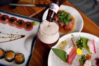 Beer Being Poured into Beer Glass and Food on the Table